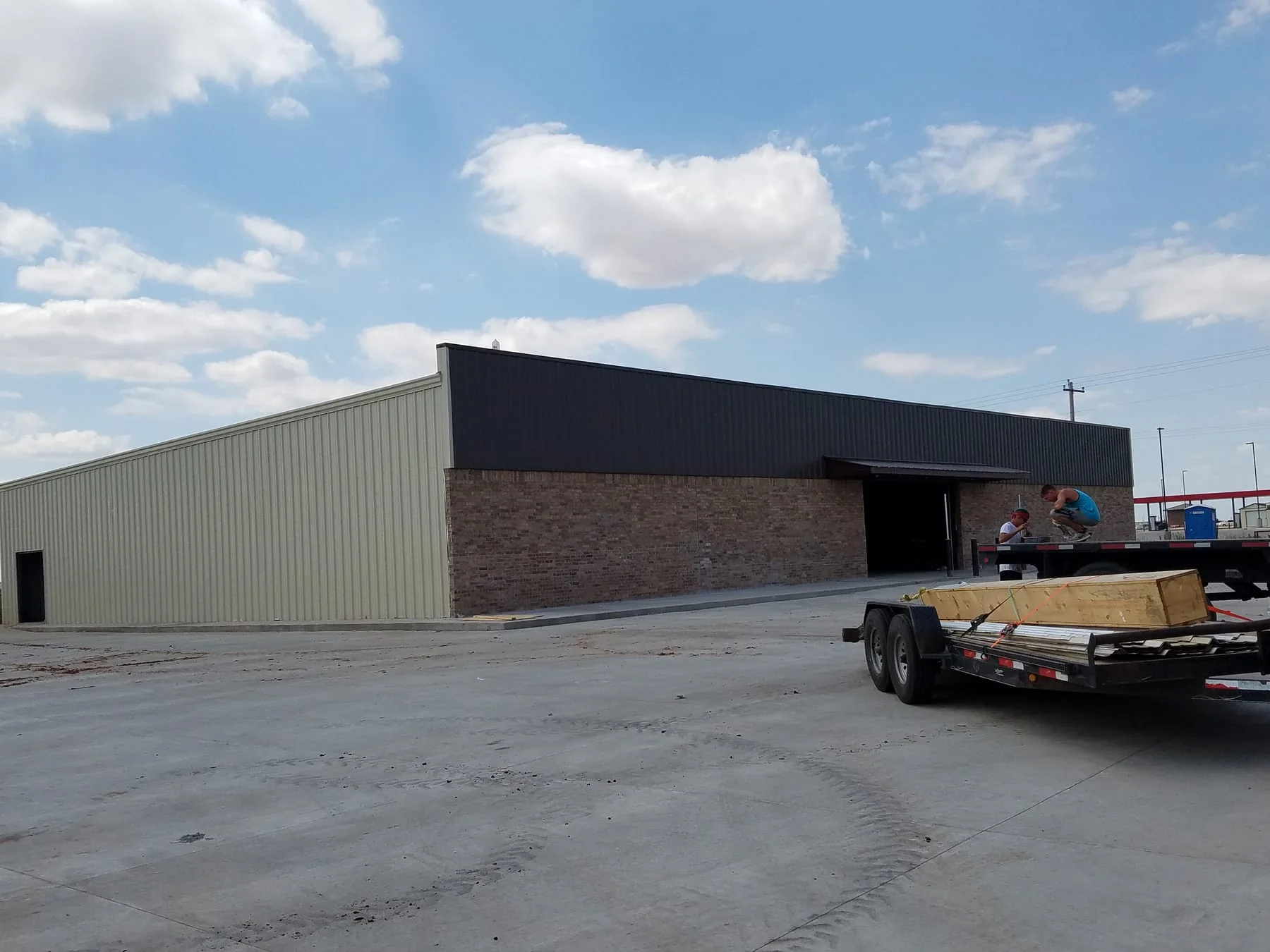 Representative archive field photo, not a matched project image: metal-sided building with a brick facade and dark upper wall panels